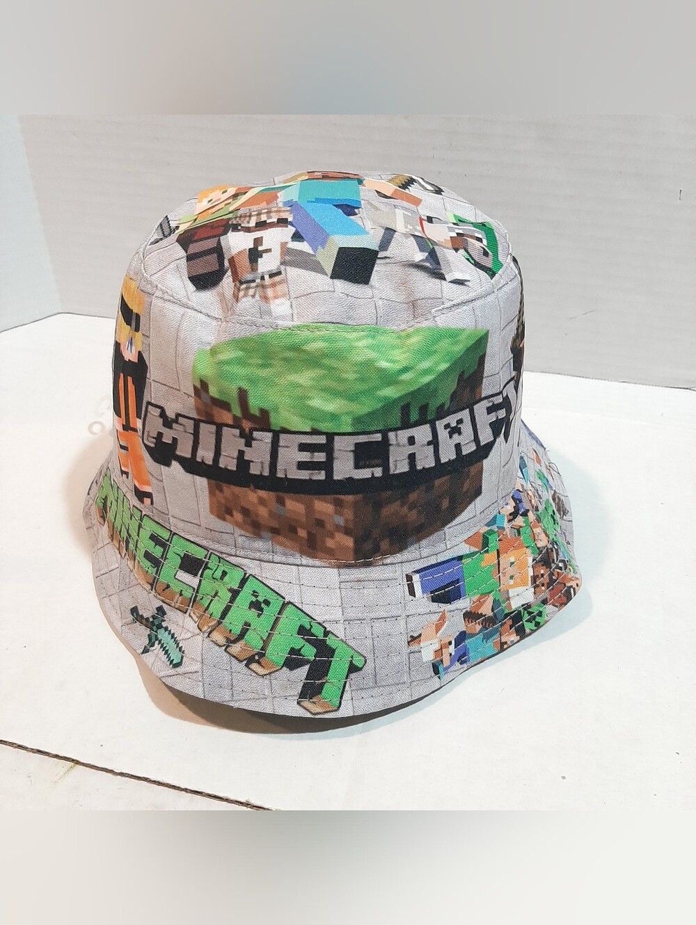 Gray Minecraft-themed youth bucket hat featuring a character and block collage